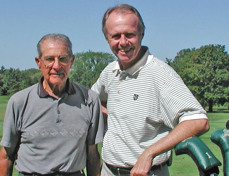 Ed LeBeau standing with Manuel de la Torre on a golf course
